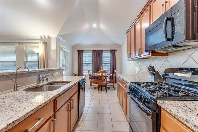 a kitchen with stove a sink and chairs