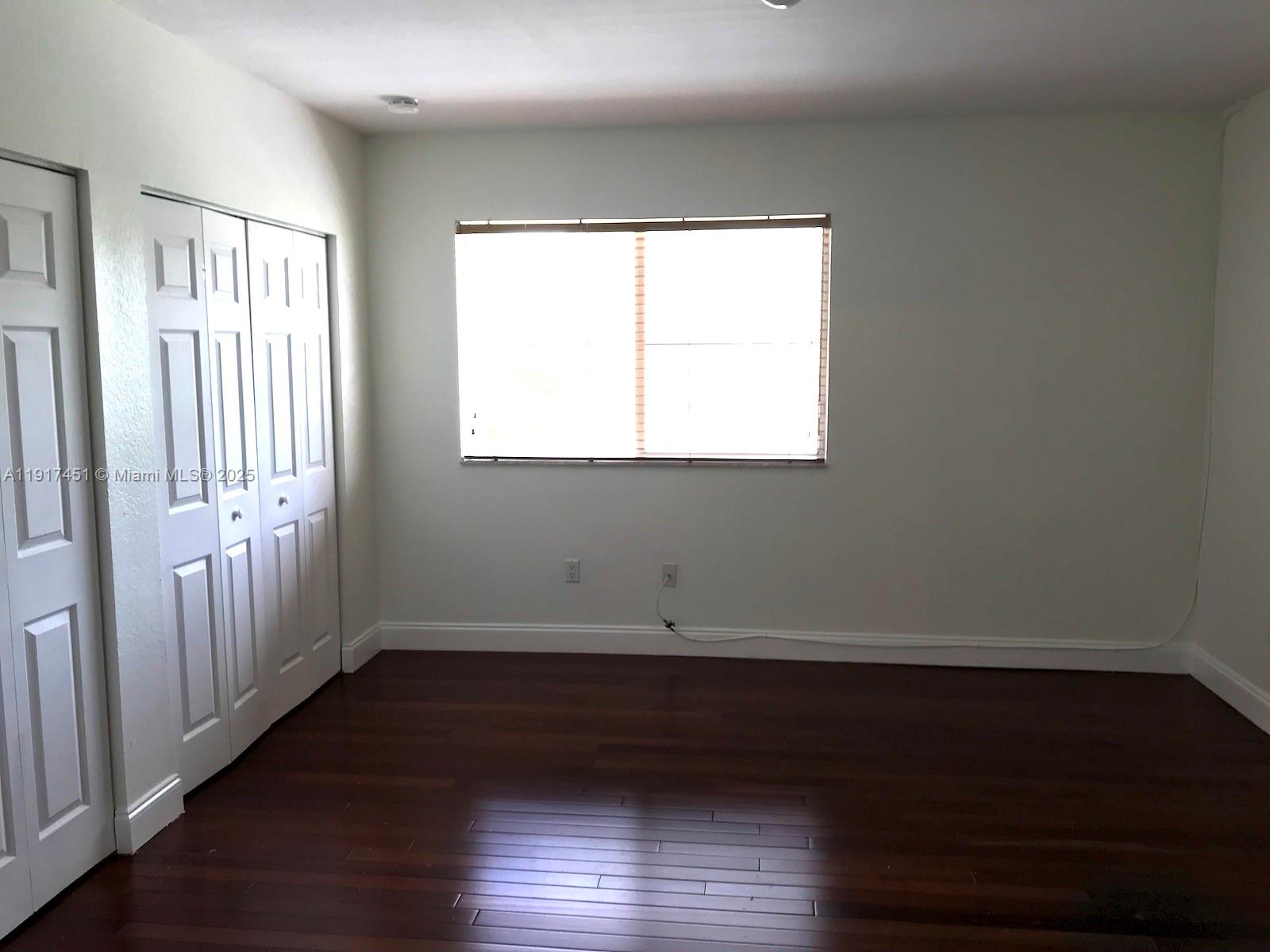 8233 Southwest 25th Court, Unit 104 Miramar, FL 33025 - Photo 15 of 22 a view of an empty room with wooden floor and a window