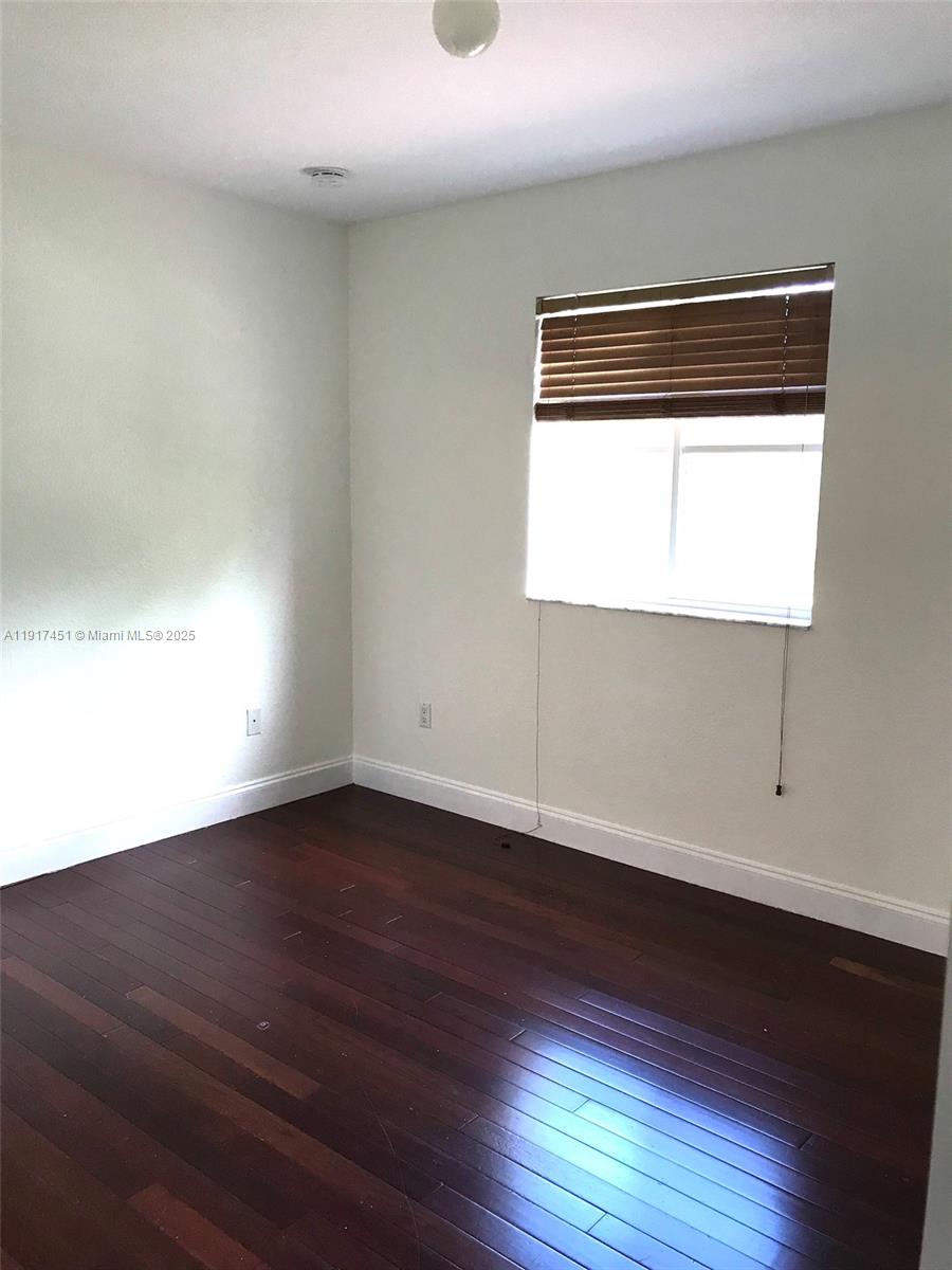 8233 Southwest 25th Court, Unit 104 Miramar, FL 33025 - Photo 17 of 22 an empty room with wooden floor and windows