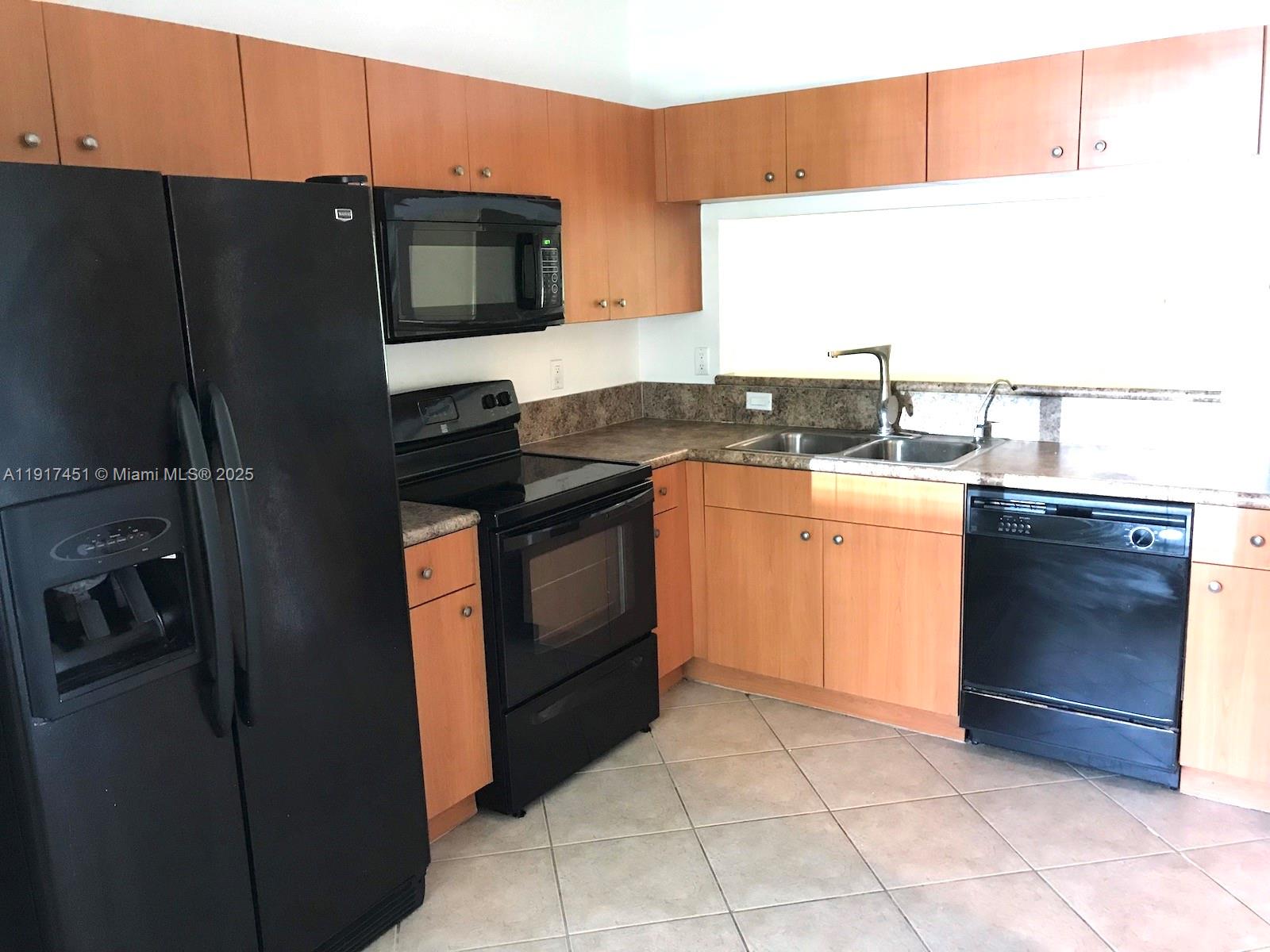 8233 Southwest 25th Court, Unit 104 Miramar, FL 33025 - Photo 8 of 22 a kitchen with stainless steel appliances granite countertop a stove a refrigerator and a sink