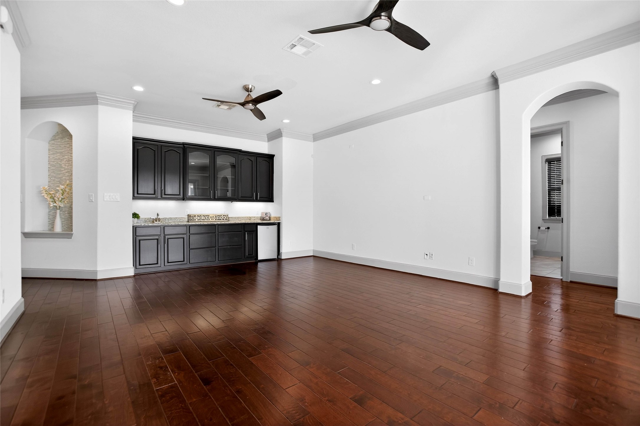 12349 Tramonto Conroe, TX 77304 - Photo 40 of 50 Game room with wet bar and cabinets. The neutral walls and recessed lighting create a bright, open feel, while arched doorways add architectural interest.