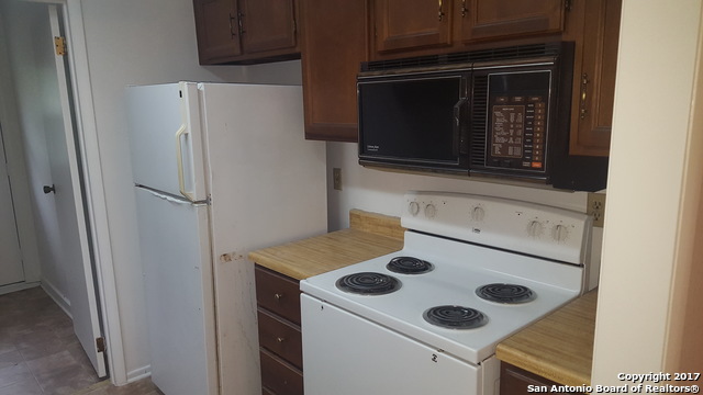 320 Station Street, Unit 101 Converse, TX 78109 - Photo 5 of 14 a white refrigerator freezer and a stove sitting inside of a kitchen