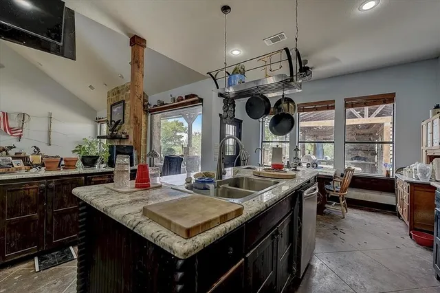 a kitchen with a stove a kitchen island a dining table and chairs with the wooden floor