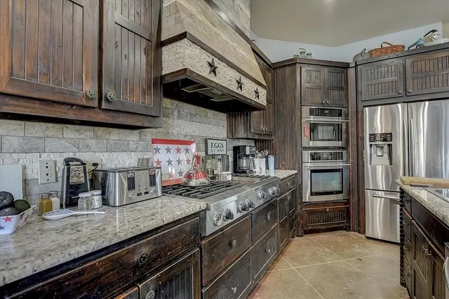 a kitchen with stainless steel appliances granite countertop a stove and a refrigerator