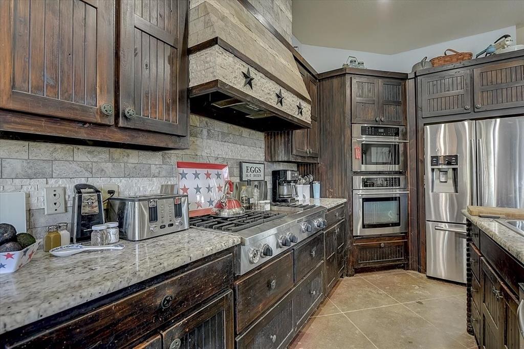 9494 Waide Road Sanger, TX 76266 - Photo 13 of 40 a kitchen with stainless steel appliances granite countertop a stove and a refrigerator