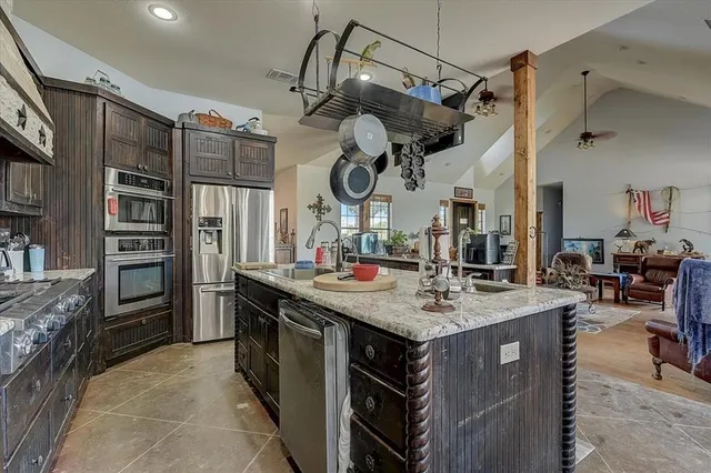 a kitchen with stainless steel appliances granite countertop a sink and cabinets