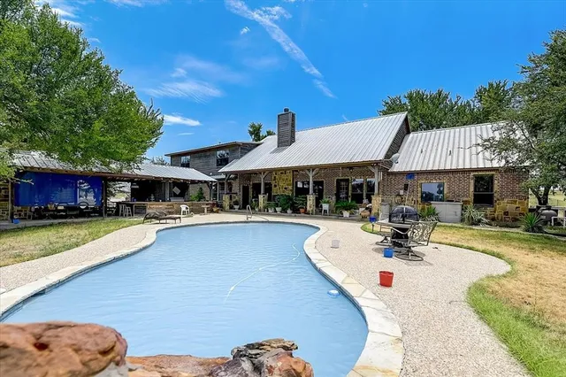 a view of a house with swimming pool and sitting area