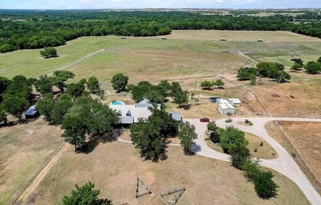 an aerial view of a house with a yard and lake view