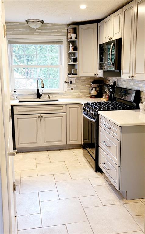 5107 McCandless Road Butler, PA 16001 - Photo 10 of 25 a kitchen with stainless steel appliances granite countertop a stove a sink and a microwave