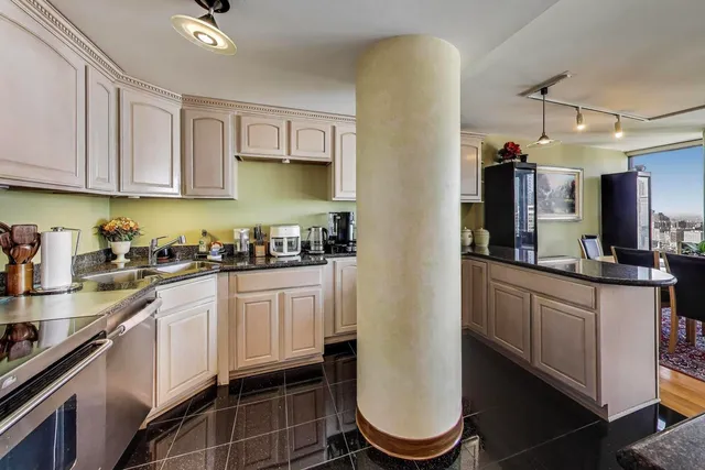 a kitchen with stainless steel appliances granite countertop a refrigerator a stove and a sink