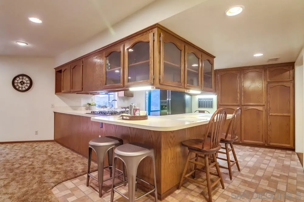 13256 Mapleview Street Lakeside, CA 92040 - Photo 22 of 58 a kitchen with kitchen island a stove a table and chairs in it