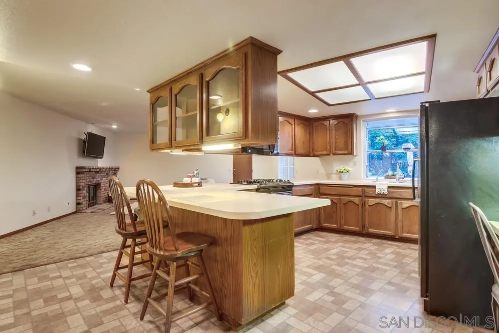 13256 Mapleview Street Lakeside, CA 92040 - Photo 23 of 58 a kitchen with a sink a refrigerator and wooden cabinets