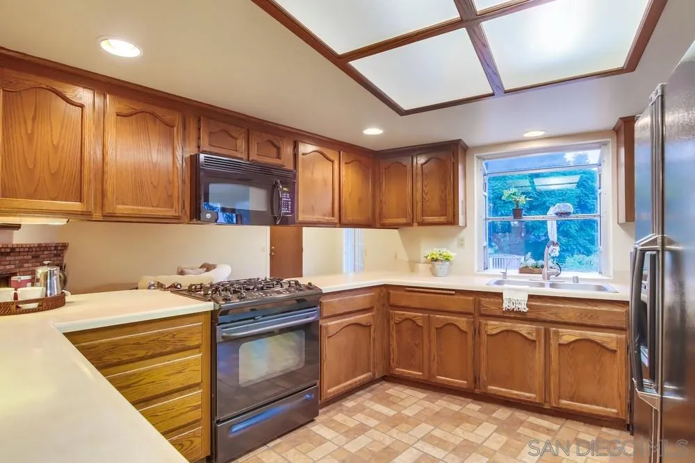 13256 Mapleview Street Lakeside, CA 92040 - Photo 25 of 58 a kitchen with a sink stove and cabinets