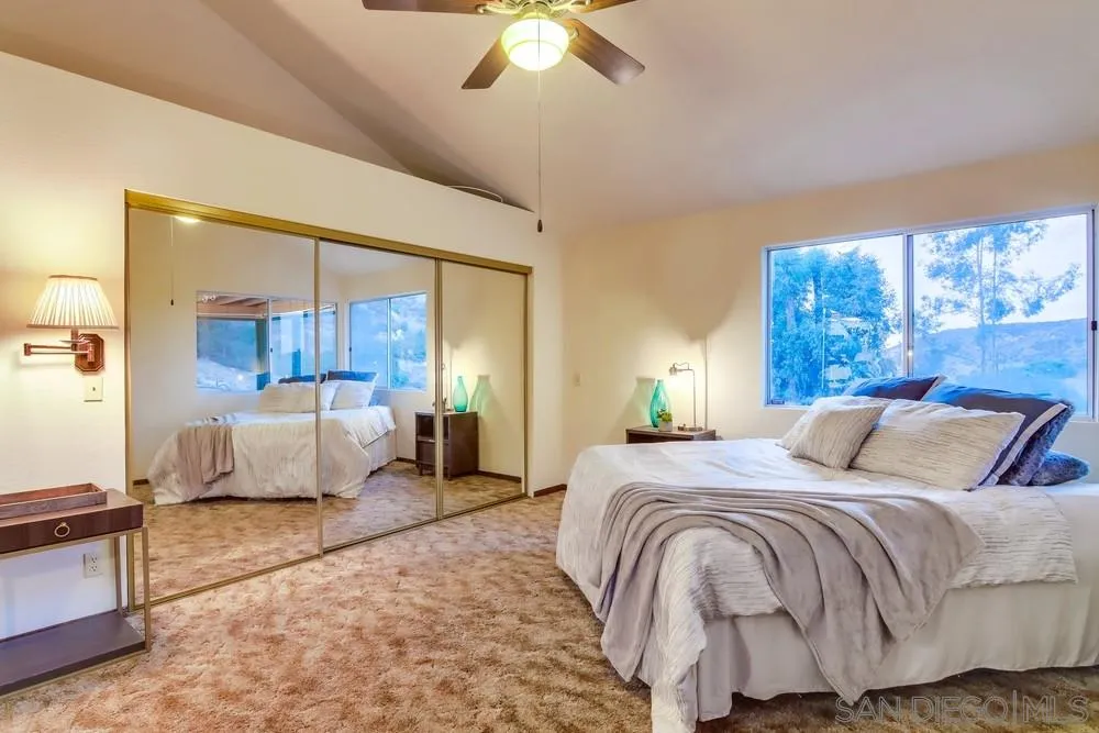13256 Mapleview Street Lakeside, CA 92040 - Photo 32 of 58 a bedroom with a large bed and a chandelier