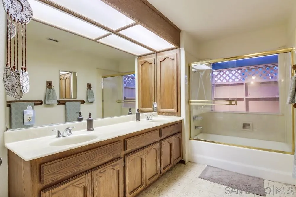 13256 Mapleview Street Lakeside, CA 92040 - Photo 37 of 58 a bathroom with a sink double vanity granite tub shower and a mirror