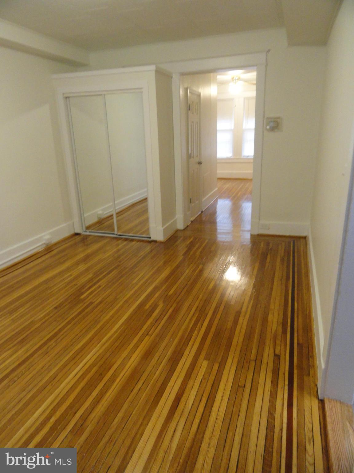 439 Quincy Street Northwest, Unit 1 Washington, DC 20011 - Photo 4 of 19 a view of an empty room with wooden floor and a window