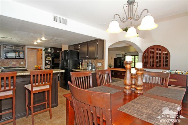 68565 Senora Road Cathedral City, CA 92234 - Photo 16 of 37 a view of a dining room with furniture a chandelier and wooden floor
