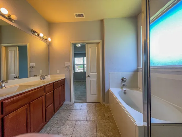a large bathroom with a tub and shower