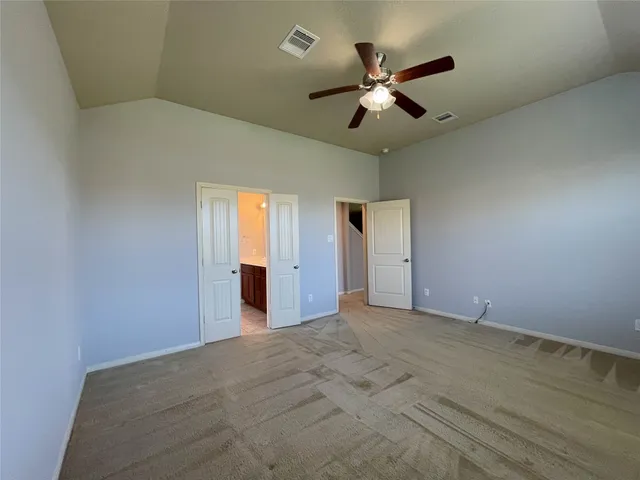 a view of an empty room with a ceiling fan