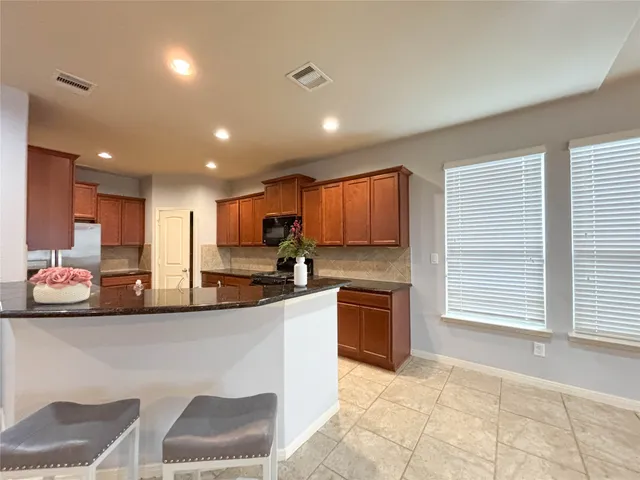 a kitchen with stainless steel appliances granite countertop a stove a sink and a refrigerator