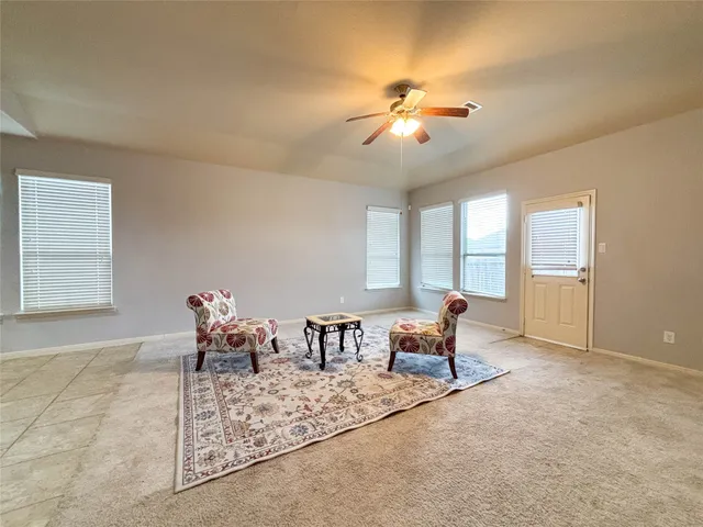 a dining room with chandelier fan and wooden floor