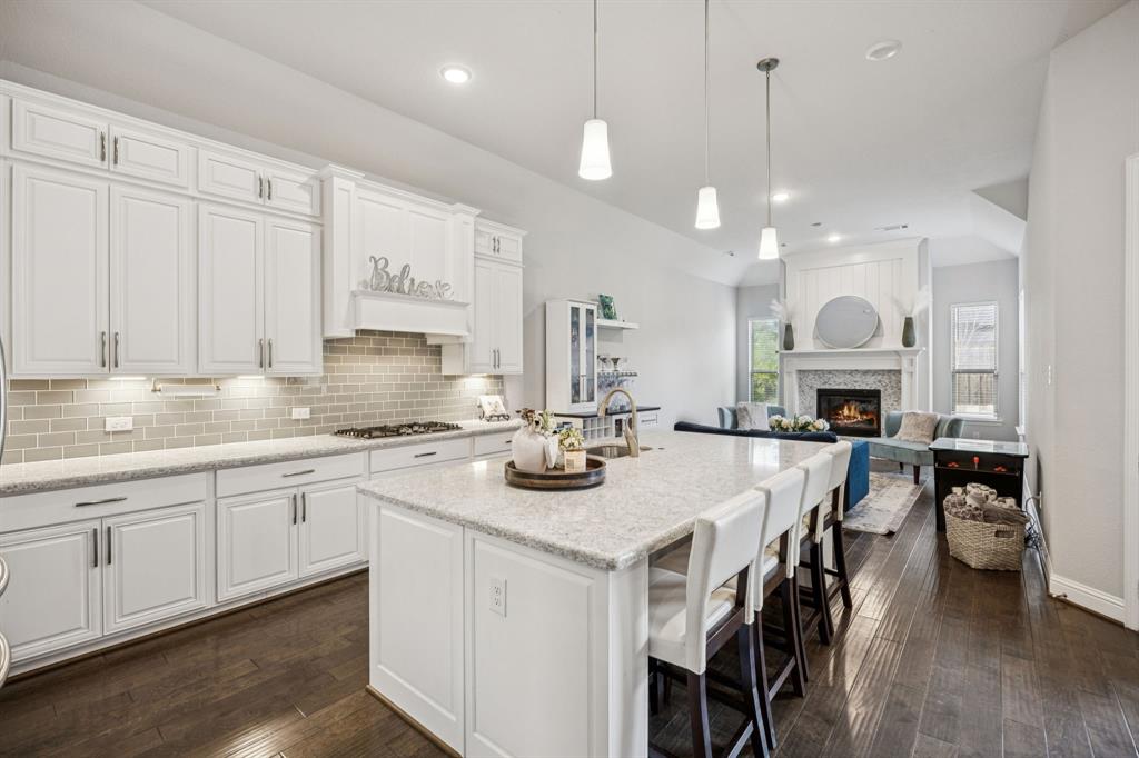 8116 Tramore The Colony, TX 75056 - Photo 12 of 36 a kitchen with cabinets a center island a stove and a chandelier