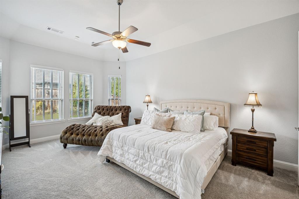 8116 Tramore The Colony, TX 75056 - Photo 15 of 36 a spacious bedroom with two beds and a chandelier