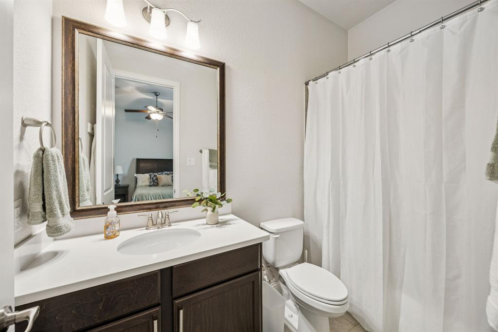 8116 Tramore The Colony, TX 75056 - Photo 21 of 36 a bathroom with a sink a toilet a mirror and shower curtain