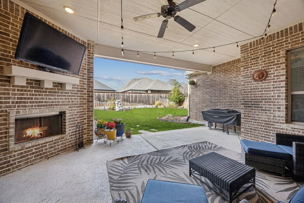 8116 Tramore The Colony, TX 75056 - Photo 24 of 36 a outdoor living space with furniture a flat screen tv and a fireplace