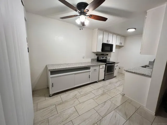 a kitchen with granite countertop a refrigerator and a stove