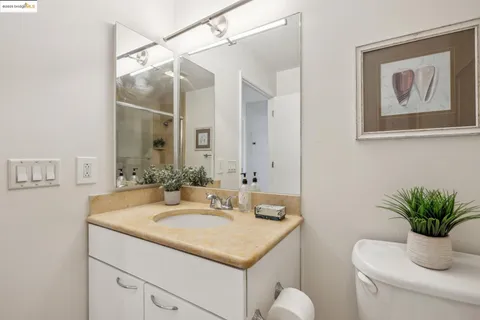 a bathroom with a granite countertop sink a toilet and a mirror