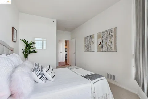 a bedroom with a large bed and a potted plant