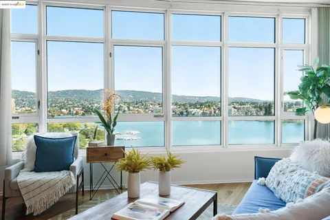 a living room with furniture and floor to ceiling windows