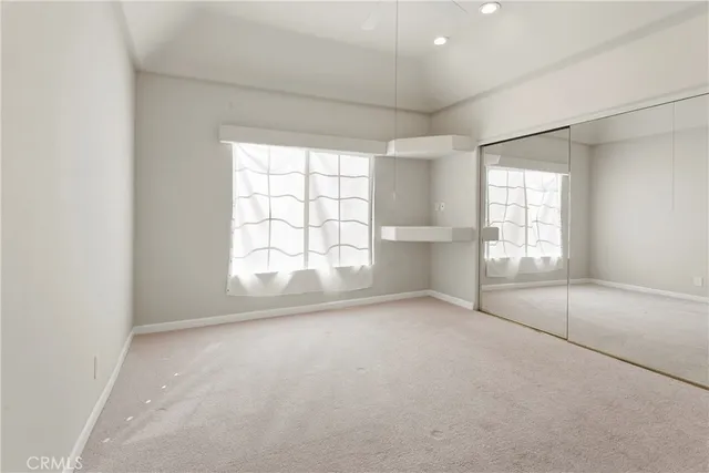 an empty room with windows and closet