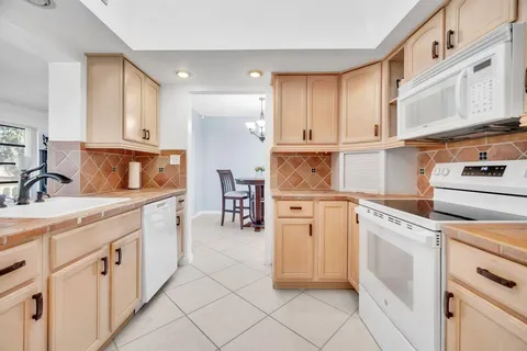 a kitchen with white cabinets and white appliances