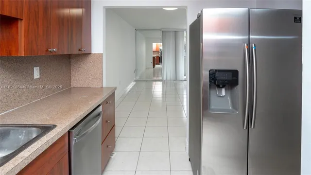 a view of a refrigerator a sink and dishwasher in a kitchen