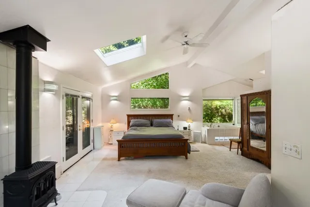 a bathroom with a tub a sink and a large window