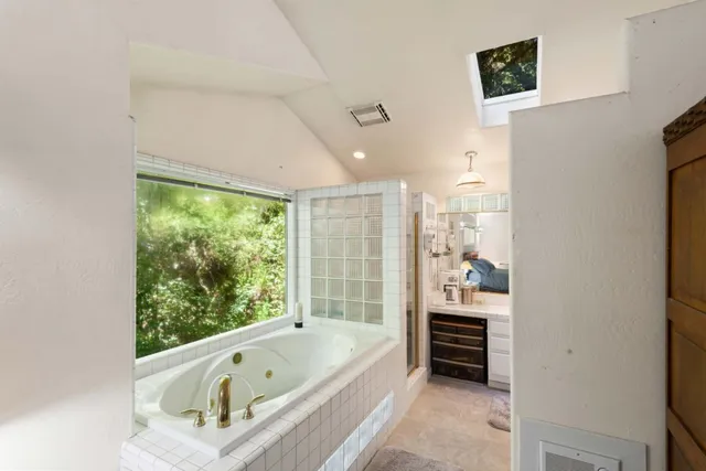 a bedroom with a bed and a flat tv screen on the dresser