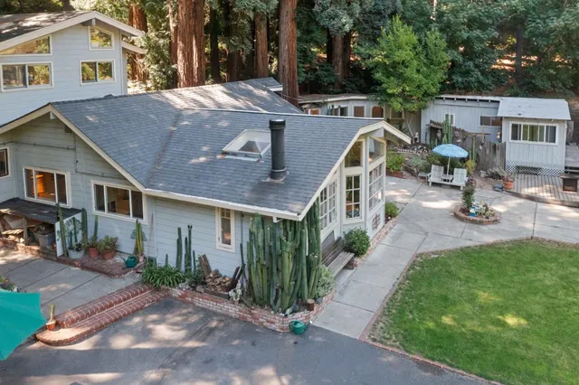 a aerial view of a house with a yard and large trees