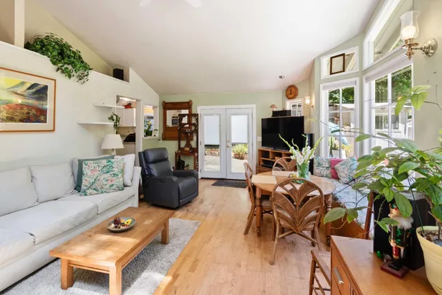 a living room with furniture a flat screen tv and a table