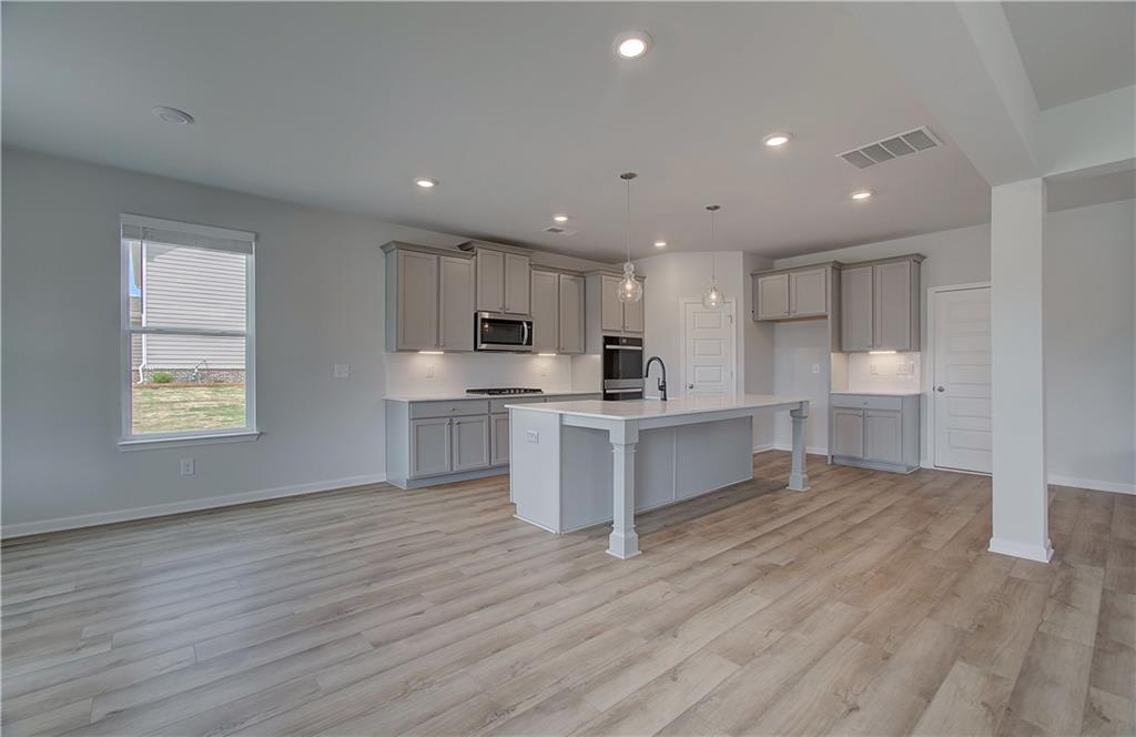 100 Felicity Pike Locust Grove, GA 30248 - Photo 16 of 38 a large kitchen with stainless steel appliances a large counter top and wooden floors