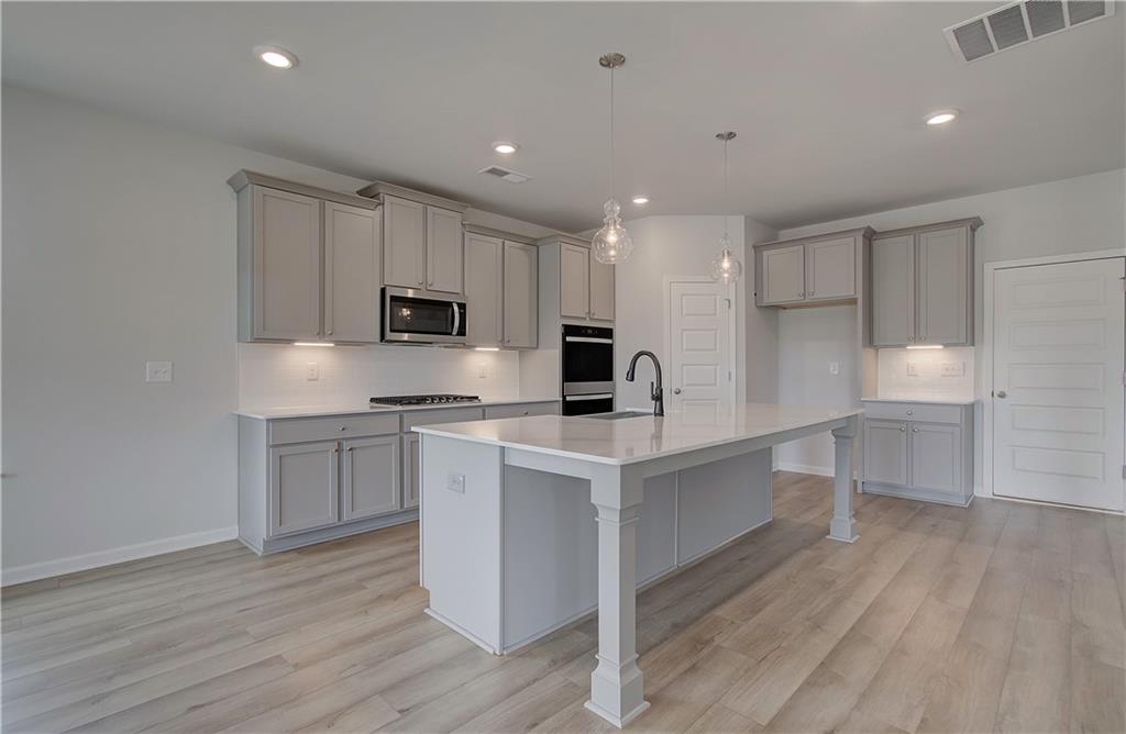 100 Felicity Pike Locust Grove, GA 30248 - Photo 18 of 38 a kitchen with a sink a microwave and cabinets