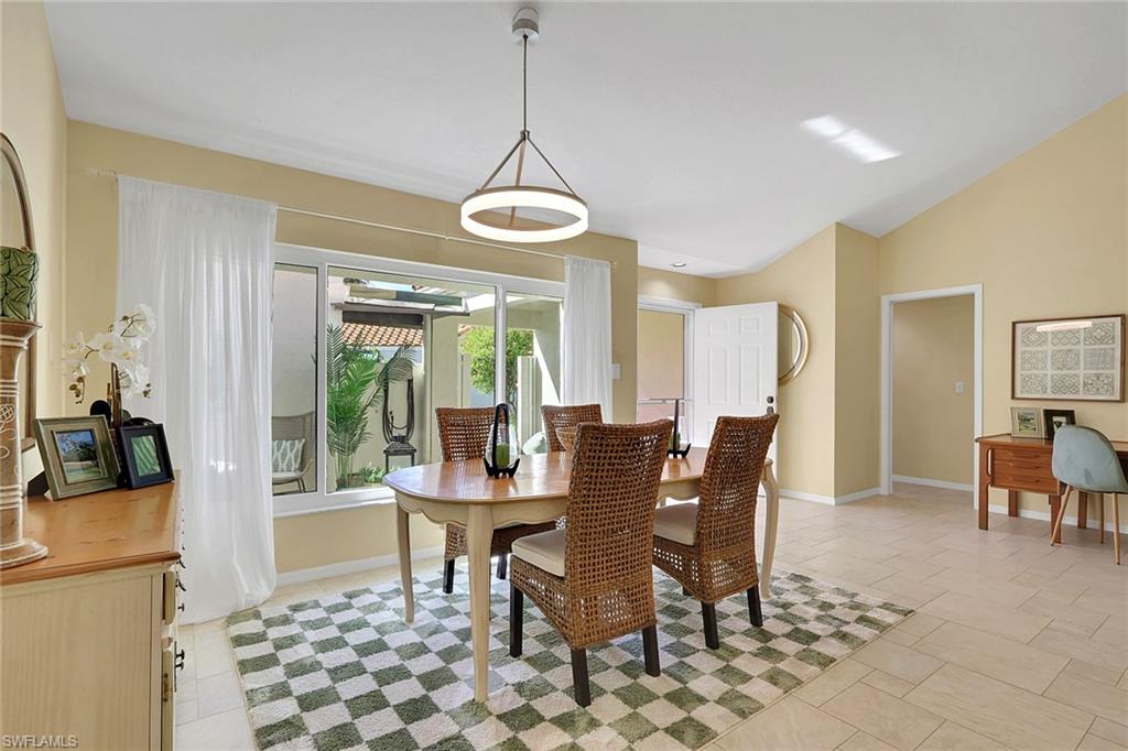796 Reef Point Circle Naples, FL 34108 - Photo 15 of 37 a dining room with furniture a chandelier and wooden floor