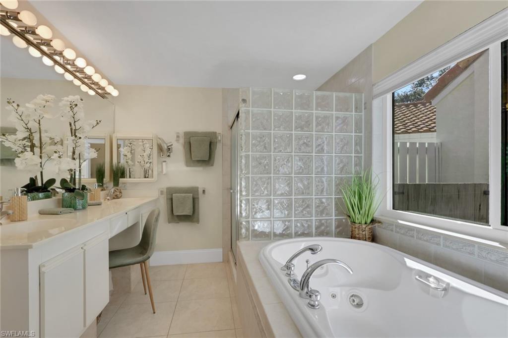 796 Reef Point Circle Naples, FL 34108 - Photo 24 of 37 a bathroom with a granite countertop tub sink and mirror