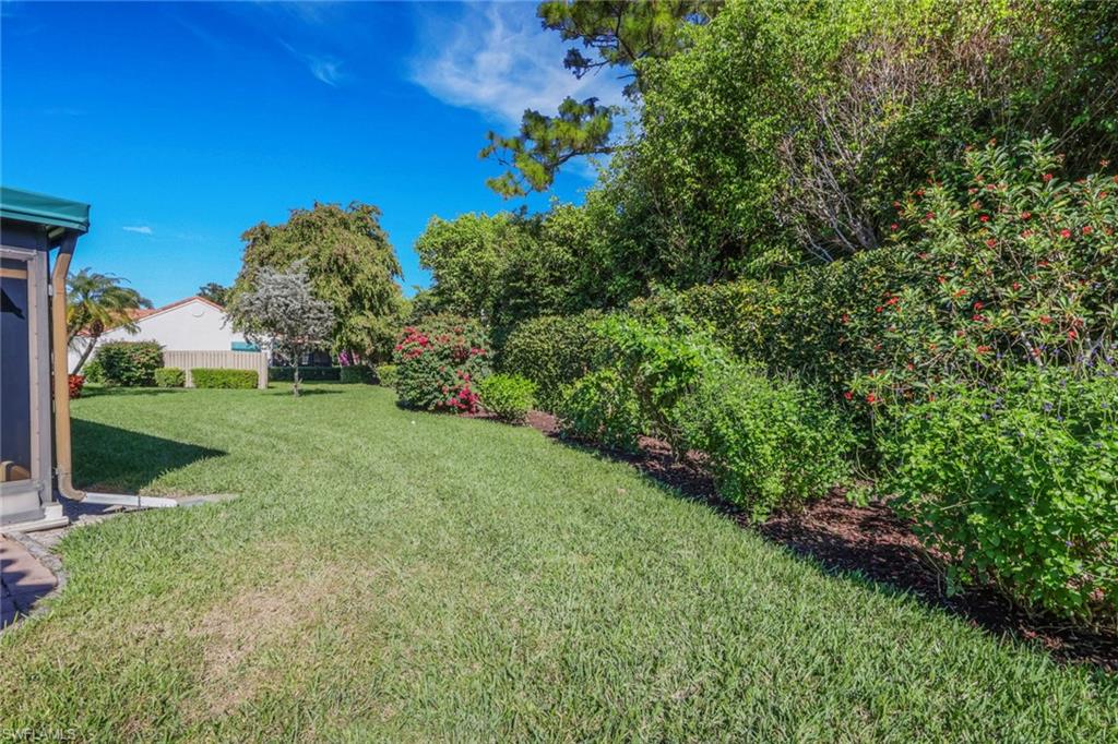 796 Reef Point Circle Naples, FL 34108 - Photo 27 of 37 a view of a garden with a building in the background