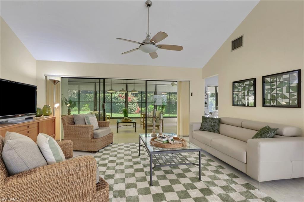 796 Reef Point Circle Naples, FL 34108 - Photo 9 of 37 a living room with furniture and a flat screen tv