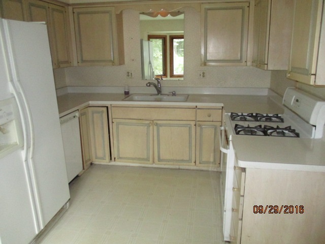 4965 Brigadoon Road Rockford, IL 61107 - Photo 7 of 13 a bathroom with a sink a mirror and a refrigerator