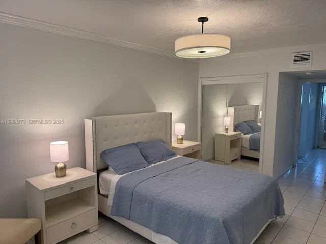 a bedroom with bed and a chandelier