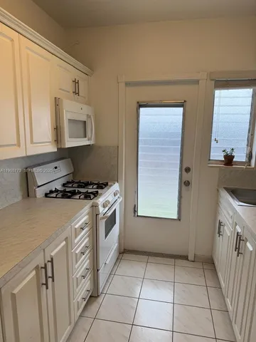 a kitchen with a stove top oven and cabinets