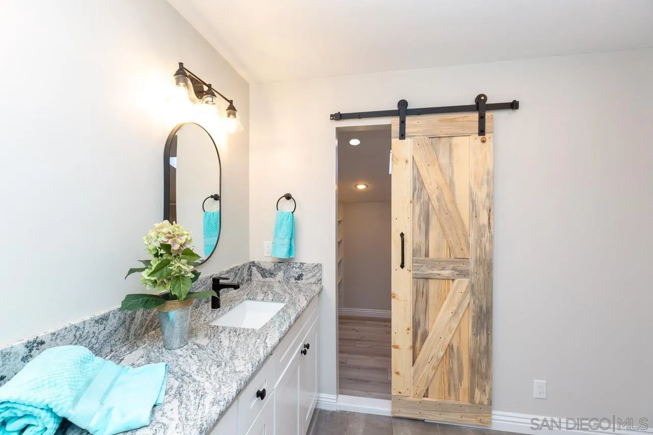 2922 Olive View Road Alpine, CA 91901 - Photo 20 of 34 a bathroom with a granite countertop sink a mirror and shower